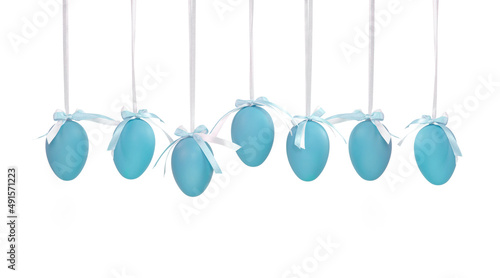 Seven blue Easter eggs hanging on white ribbons with a small bow isolated on a white background. Monochrome Easter eggs.