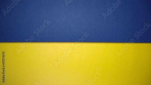 Blue and yellow paper rolling on green screen. Blue and yellow are colors of Ukraine national flag.