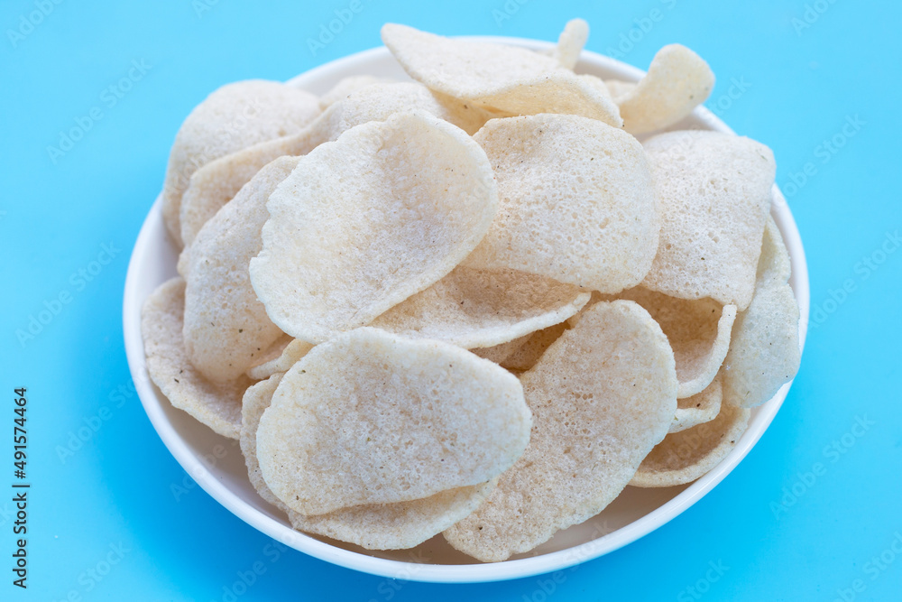 Prawn crackers on blue background. Shrimp crispy rice snack Prawn crackers on blue background. Shrimp crispy rice snack