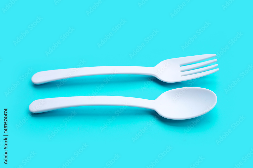 Plastic fork and spoon on blue background. Plastic fork and spoon on blue background.