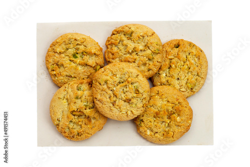 Pistachio and almond cookies on brown paper on white background.