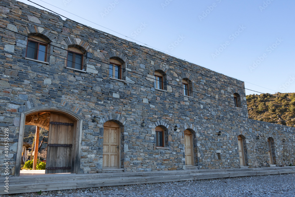 Stone wall hotel with lots of window. It has wooden doors. Medieval architecture.