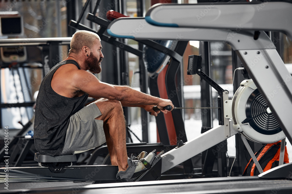 Training legs in the simulator, the athlete works with his legs on the simulator, working out the muscles on the legs Training legs in the simulator, the athlete works with his legs on the simulator, working out the muscles on the legs
