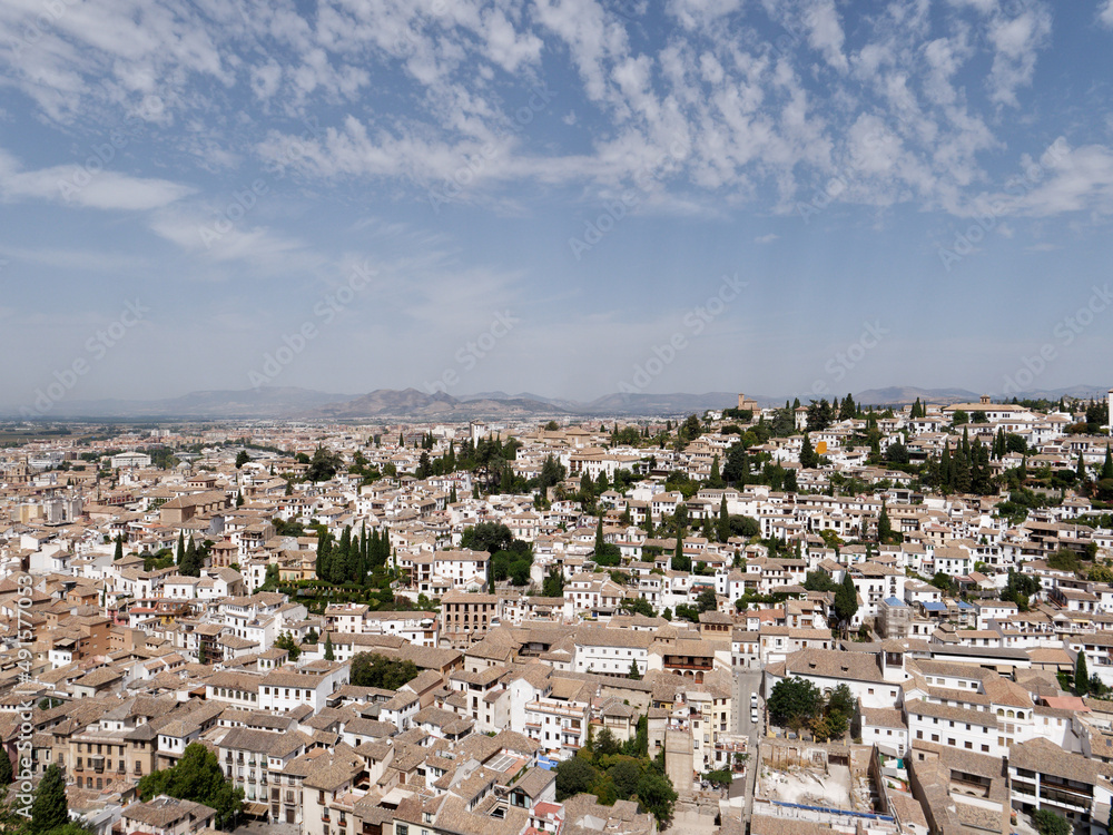 Panoramic view of the city of Granada in Spain. Old and multicultural town. Sunny day, blue sky and some clouds. Heritage Spain.
