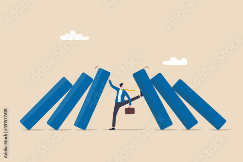 Crisis management, leadership to manage disaster situation, challenge to overcome difficulty in economic crisis concept, confident businessman use his hand to stop domino fall and foot to stop others.