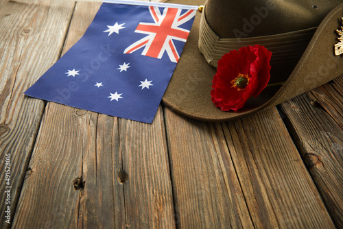 Anzac army slouch hat with Australian Flag and Poppy on wooden background photo