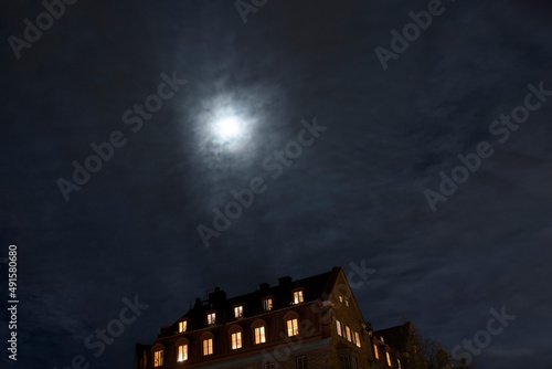 Moon over multistorey townhouses at night