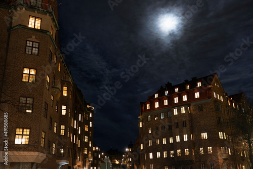 Moon over multistorey townhouses at night photo