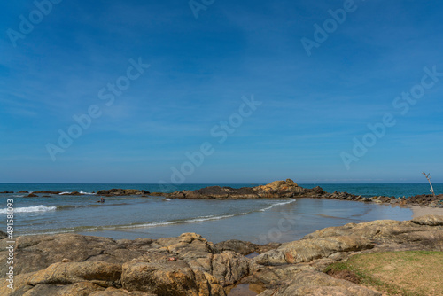 Rocks at the Bentota beach, background blue sky Indian Ocean, Sri Lanka