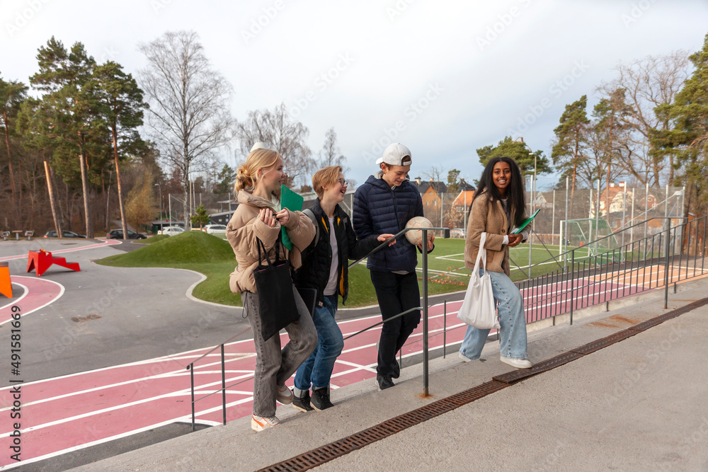 Teenage friends walking up school stairs Teenage friends walking up school stairs