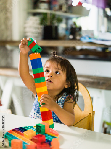 Girl stacking blocks at table photo