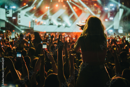 Fotografia Silhouette of a woman with raised hands on a concert