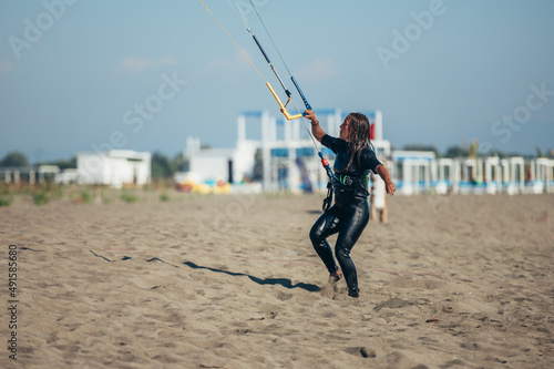 Woman using control bar to lift her kite up for kitesurfing