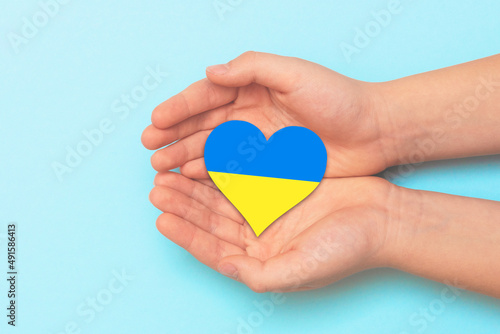 Hand holding a heart with Ukrainian national colors