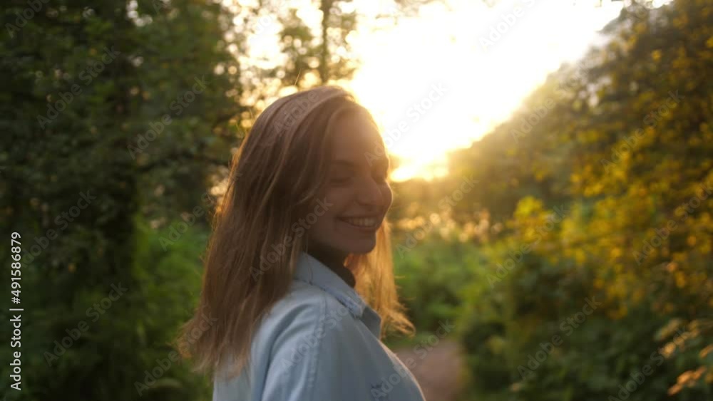 Happy young woman beckons and walks along path among bushes and sunshine. slow motion Happy young woman beckons and walks along path among bushes and sunshine. slow motion