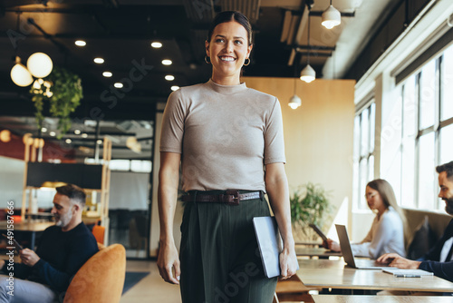 Happy businesswoman standing in a co-working space