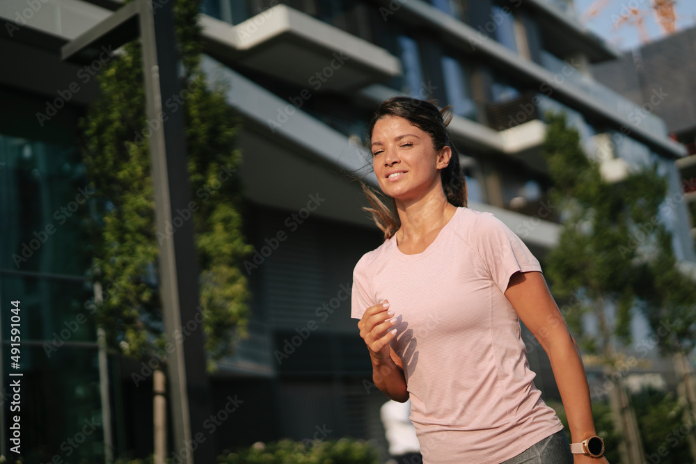 Fit athlete woman in sportswear outdoors. Young woman jogging outside.