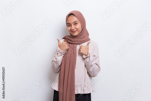 young asian beautiful muslim woman with ok sign gesture tumb up isolated on white background  © dwi