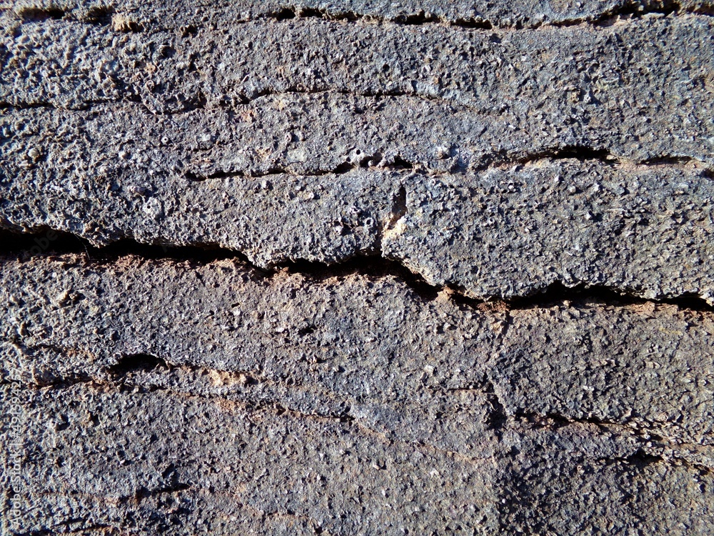 Grayish-brown stone surface with horizontal cracks, texture, wallpaper, background.
Grayish-brown stone surface with horizontal cracks, texture, wallpaper, background.