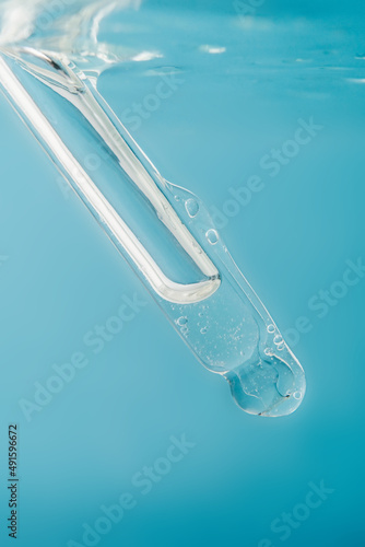 Pipette with cosmetic product in water with bubbles. © Marevgenna