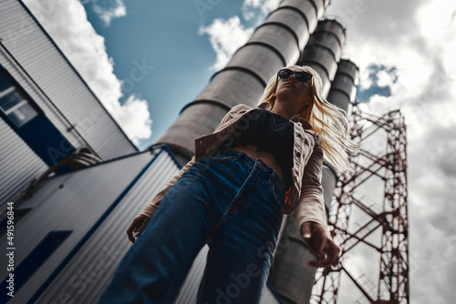 Blonde on a background of a plant with pipes