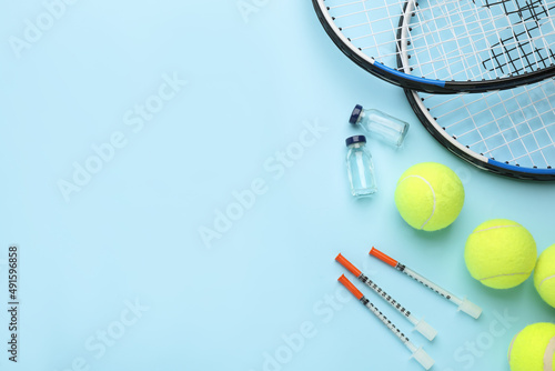 Tennis rackets, balls and drugs on light blue background, flat lay with space for text. Doping concept