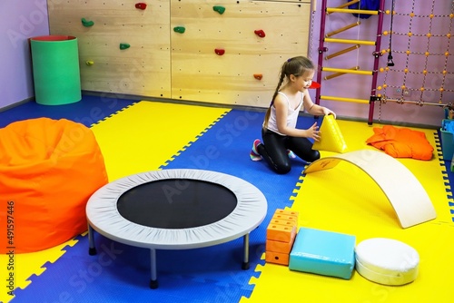 an autistic girl is treated in the form of a game by a psychologist, exercises on the ballancer help the brain, balance