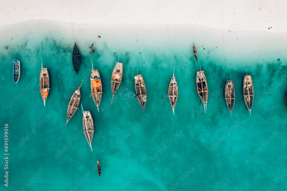 Top view or aerial view of Beautiful crystal clear water and white beach with long tail boats in summer of Zanzibar island - obrazy, fototapety, plakaty 