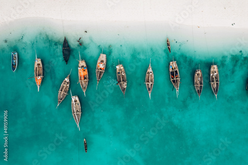 Top view or aerial view of Beautiful crystal clear water and white beach with long tail boats in summer of Zanzibar island