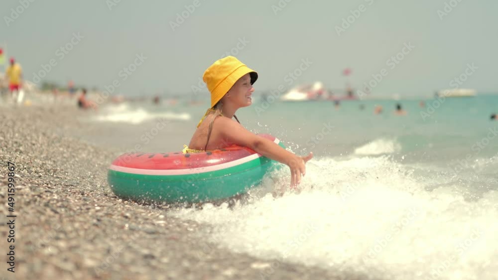 Summer vacation concept. Happy child in the sea. Young girl playing in the wave in beach. Young lady sitting in foam of sea. Summer vacation concept. Happy child in the sea. Young girl playing in the wave in beach. Young lady sitting in foam of sea.