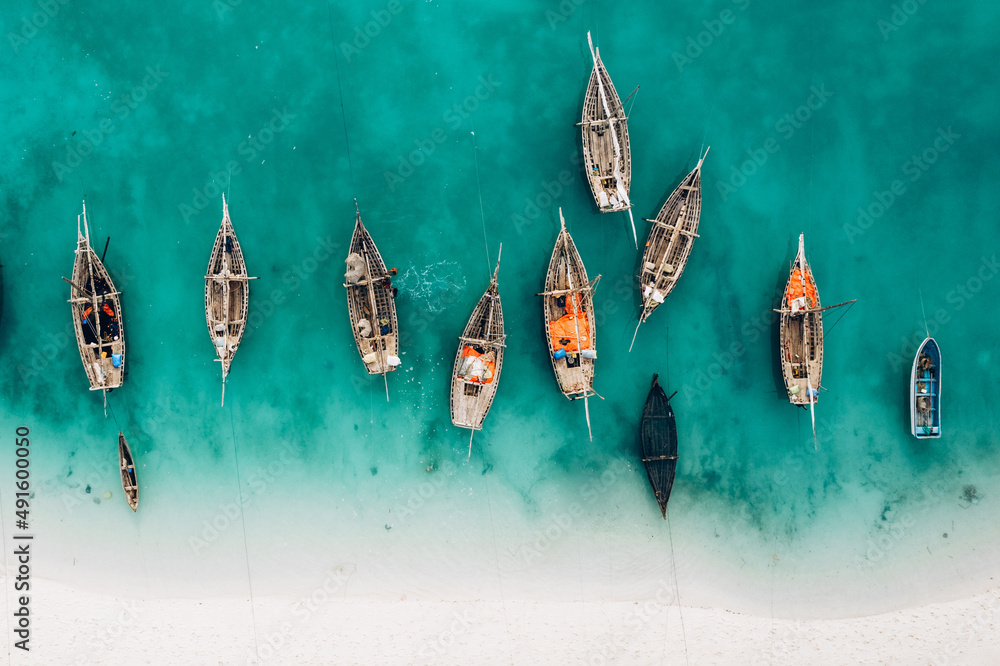 Top view or aerial view of Beautiful crystal clear water and white beach with long tail boats in summer of Zanzibar island - obrazy, fototapety, plakaty 