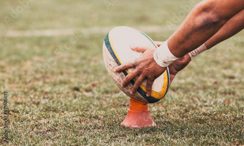 rugby player preparing to kick the oval ball during game