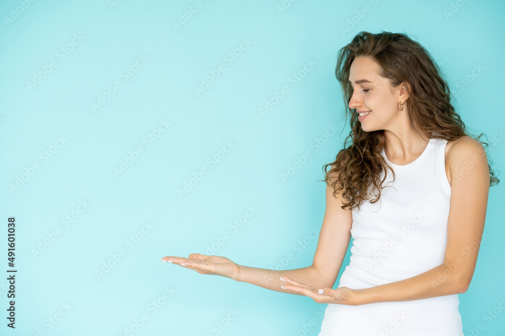 Invisible surprise. Happy woman. Sale promotion. Pretty elegant smiling lady holding hands up isolated blue looking copy space. Invisible surprise. Happy woman. Sale promotion. Pretty elegant smiling lady holding hands up isolated blue looking copy space.