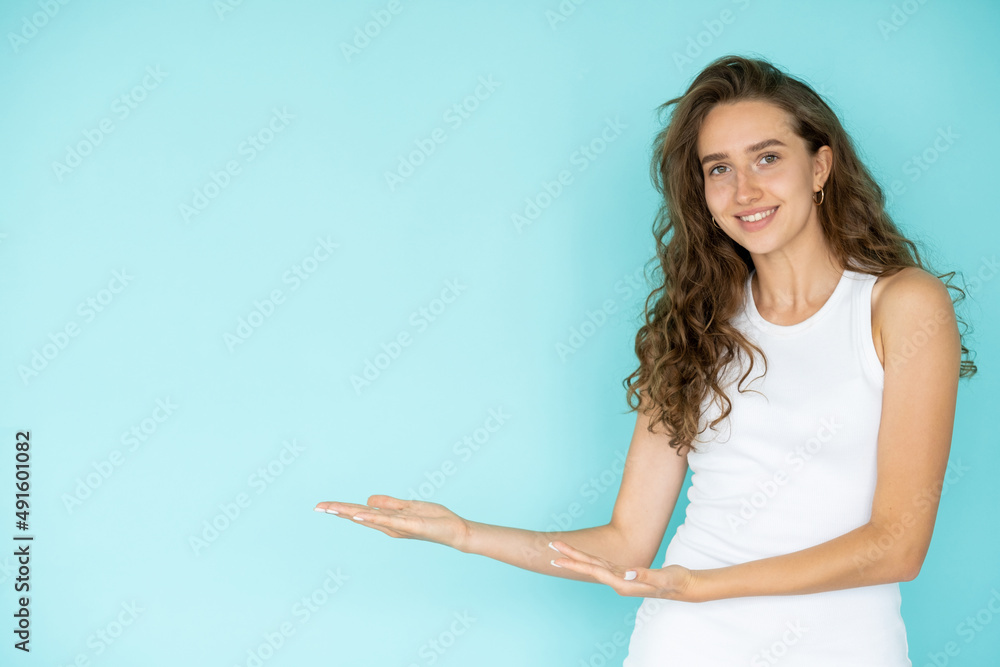 Invisible product. Inspired woman. Promotion gesture. Pretty elegant smiling lady holding hands up with open palm isolated blue copy space. Invisible product. Inspired woman. Promotion gesture. Pretty elegant smiling lady holding hands up with open palm isolated blue copy space.