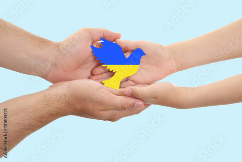 Wallpaper Mural Hands of family with small dove in colors of Ukrainian flag on light background. War in Ukraine Torontodigital.ca