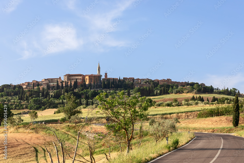 Road winding between the green hills of Tuscany and leading to the medieval town of Pienza