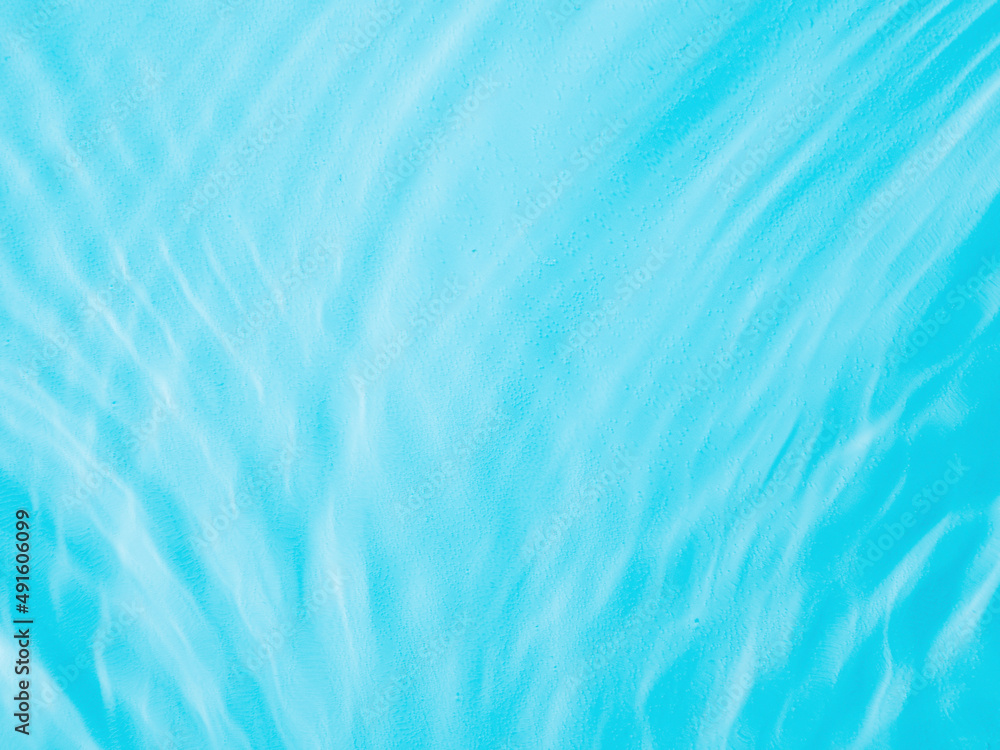 Ripple water texture on blue pool background. Shadow of water on sunlight. Mockup for product, spa or travel background. Marble blue water surface as wallpaper background Ripple water texture on blue pool background. Shadow of water on sunlight. Mockup for product, spa or travel background. Marble blue water surface as wallpaper background