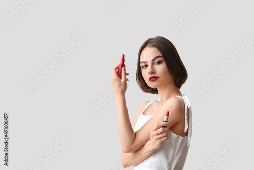 Young woman holding red lip...