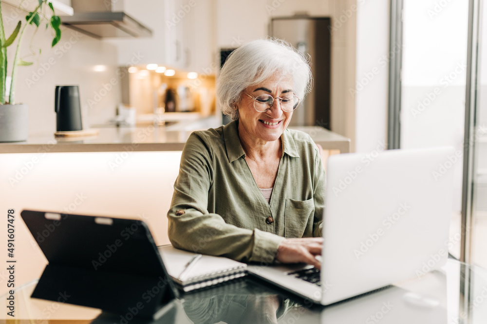 Happy senior businesswoman working in her home office Happy senior businesswoman working in her home office