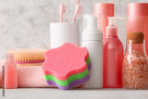 Set of different cosmetic products and bath accessories on light background  closeup