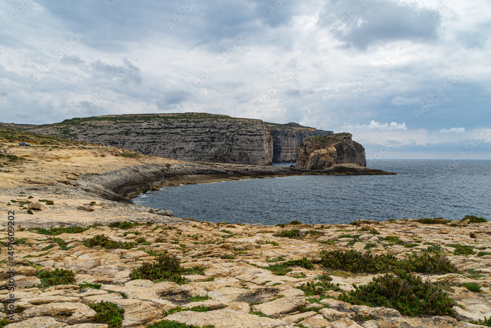 The rocky shore near Dwejra Bay, Gozo. In the background is the islet Fungus Rock aka Il-Ġebla tal-Ġeneral (The General's Rock).