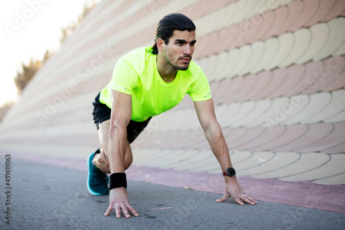 Young muscle man training outside. Fit handsome man doing exercise.