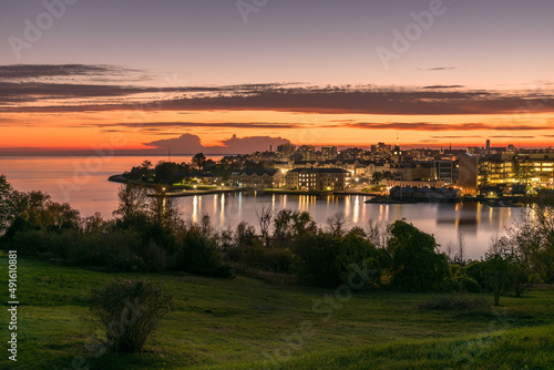 View of a city on a lake at Dusk. Reflection in water. Kingston, ON, Canada. photo