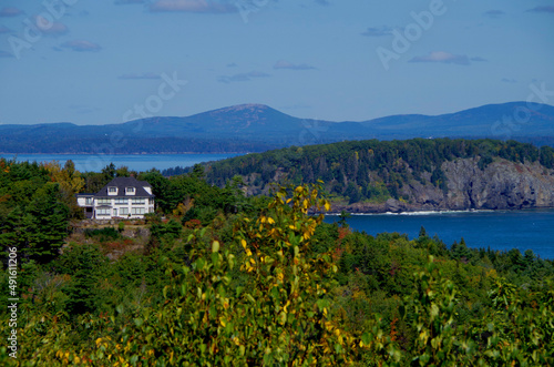 Panoramic scenic landscape view of coast and Indian summer stage fall season in Acadia National Park with Cadillac Mountain lookout and tree leaves in colors of autumn on sunny day blue sky