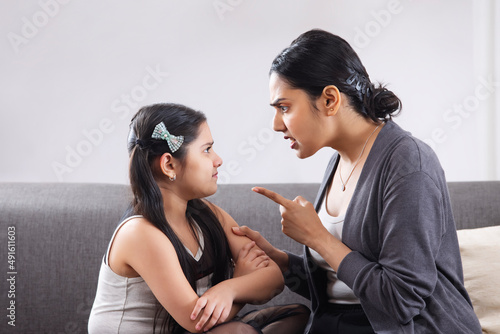 An angry mother ruling her daughter by pointing a finger