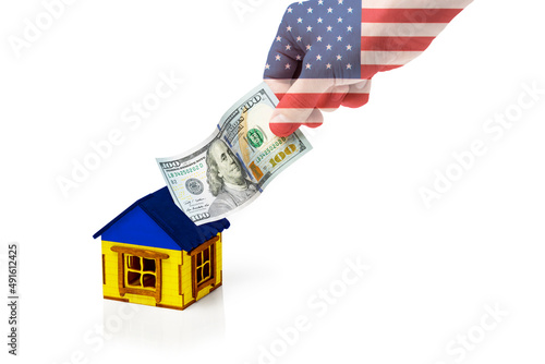 Hand with an American flag puts one hundred dollars in a house isolated on a white background. Concept of funding Ukraine from the United States. photo