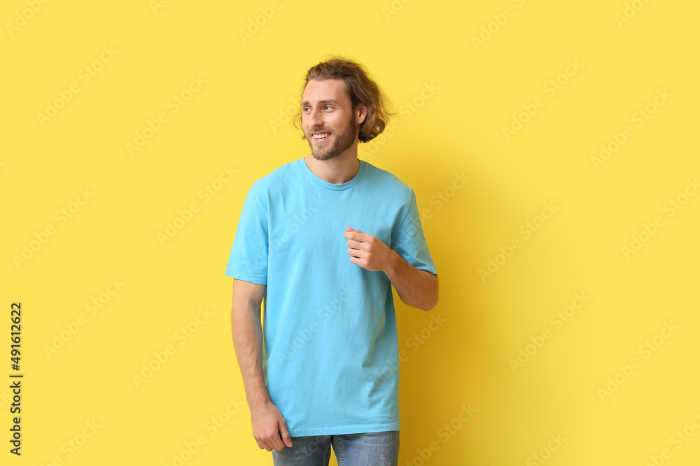 Handsome young man in stylish t-shirt on yellow background Handsome young man in stylish t-shirt on yellow background
