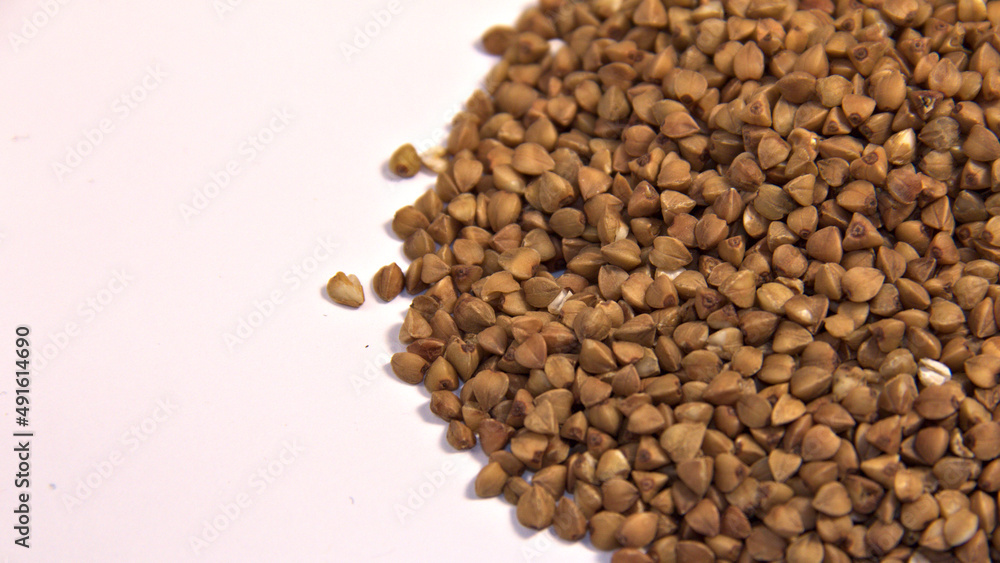 Sprinkled buckwheat on a white background. Close up. Sprinkled buckwheat on a white background. Close up.