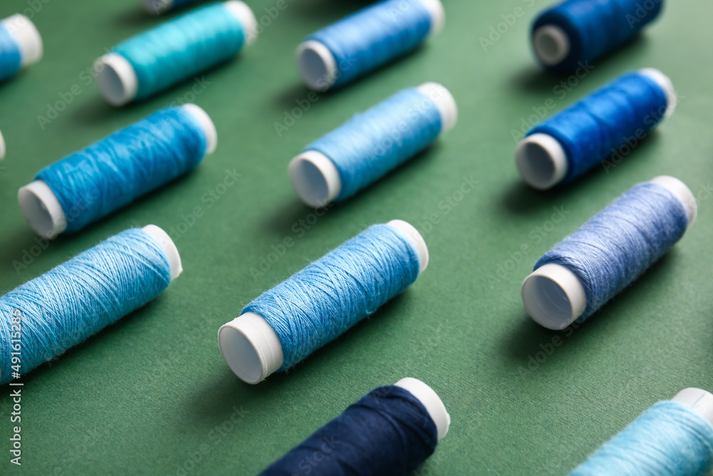Thread spools on green background, closeup Thread spools on green background, closeup