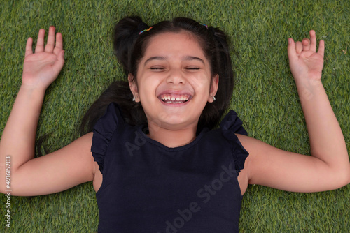 Overhead view of girl child lying on grass